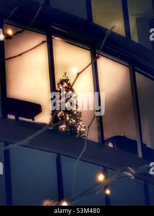 Shot of a Christmas tree glowing many floors up in a skyscraper in downtown Salt Lake City, Utah, USA. Stock Photo