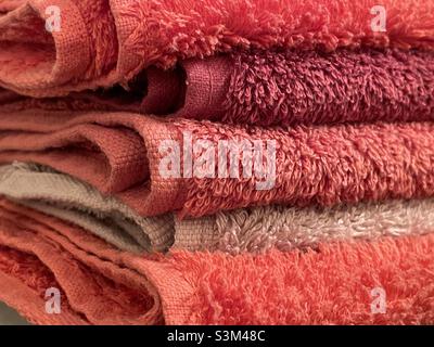 A pile of coloured folded towels seen from the edge Stock Photo