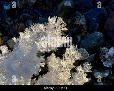 Nature’s creative elegance: Ice sculptures, ice flowers, hoar frost and snow, combined with the clear waters and coloured rocks of the Yukon River. Close-up winter wonderland. Stock Photo