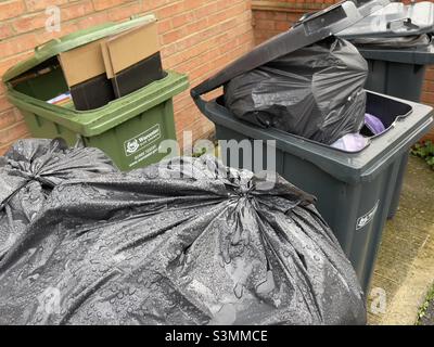Overloaded dustbins waiting for collection in a Worcester suburb Stock Photo