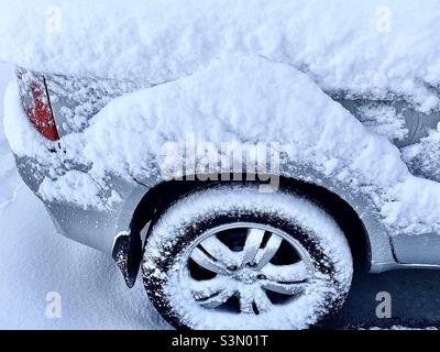 Morning after a heavy snowstorm drops a foot of snowfall in Utah, USA. This SUV was outside in a home’s driveway and is caked with the blowing snow from the night before. Stock Photo