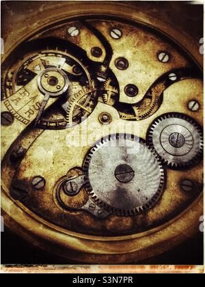 Closeup of the clockwork of an antique brass pocket watch with grunge effect. Stock Photo