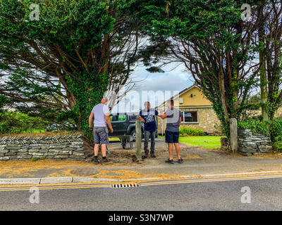 Three friends building a wall at home in Cornwall Stock Photo