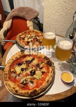 Two pizzas and two beers on a restaurant table in Manchester U.K. Stock Photo