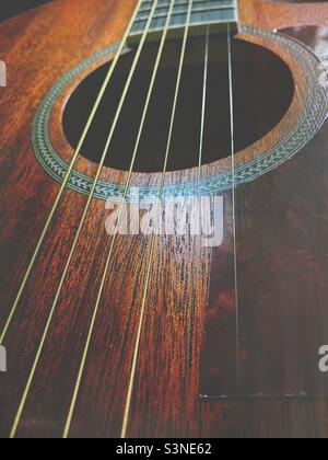 A close up of a mahogany acoustic Orangewood guitars soundboard, strings and sound hole. Stock Photo