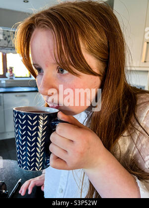 Young girl drinking cup of flavoured tea Stock Photo