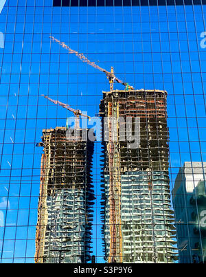 New construction of residential towers reflected in another newly finished building during the construction boom in Seattle, Washington Stock Photo