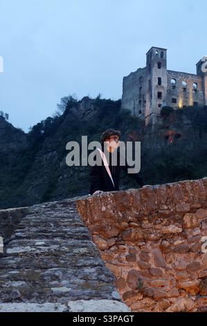 A man taking in the sights from the Ponte Vecchio in the medieval village of Dolceacqua in Italy. Stock Photo