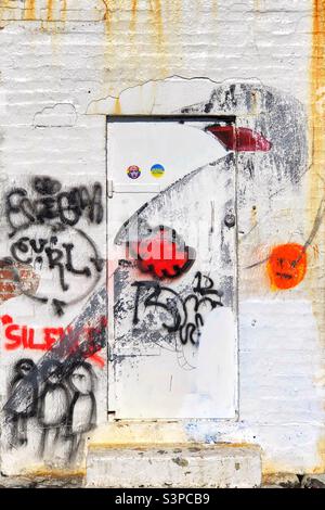 Graffitied wall and door on a ruined out building Stock Photo