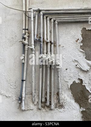 Painted water pipes on the outside wall of a residential building Stock Photo