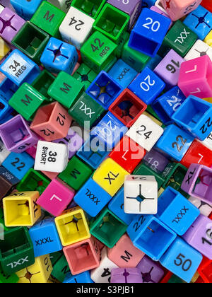 Small, coloured plastic cubes with clothes sizes to add to clothes hangers in a shop to indicate the size of a garment. Stock Photo