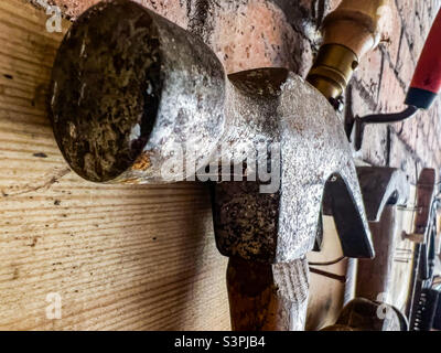 Claw Hammer and tools hanging on garage wall Stock Photo