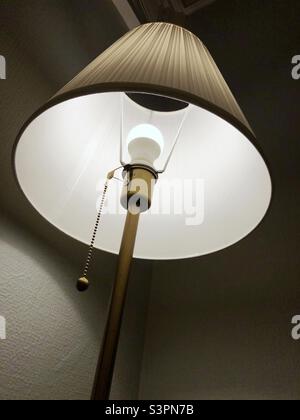 Standard floor lamp lit up in the evening Stock Photo