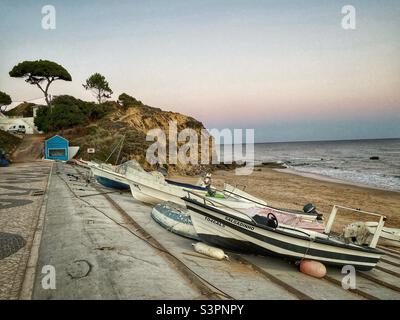 Sunset view with boats parked on a beach in Olhos de Agua, Algarve, Portugal. Stock Photo