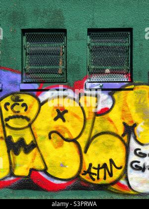 Graffitied wall on a green outbuilding Stock Photo