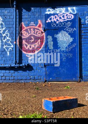 Graffiti covered outbuilding and blue coloured brick Stock Photo