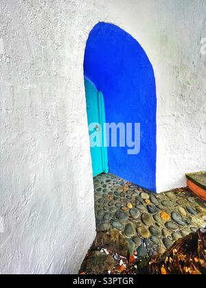 Hidden doorway set into a whitewashed wall at Portmeirion, Gwynedd, North Wales. Stock Photo