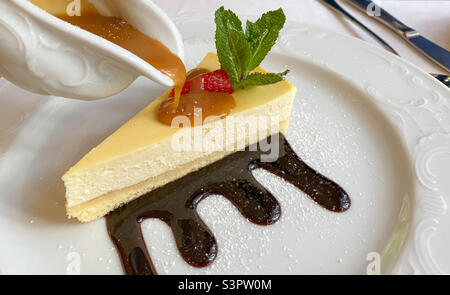 Cheesecake is a sweet dessert consisting of several layers.  The main layer consists of a mixture of soft fresh cheese, eggs and sugar.  The bottom layer consists of crushed cookies Stock Photo