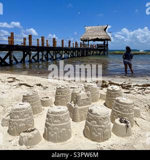 Sand castles on the beach with a pier and beach hut in Mexico Caribbean Sea Stock Photo