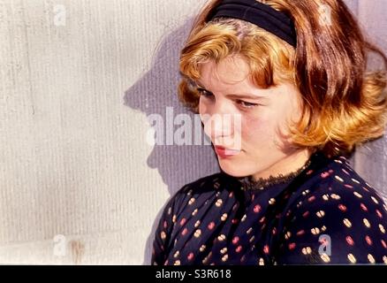 Young woman portrait thinking against wall with shadow Stock Photo
