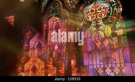 Colorful abstract pattern created with prism in front of camera lens. Overlapping image of stained glass detail with green and orange reflections Stock Photo
