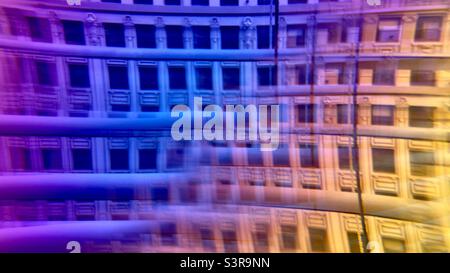 Colorful abstract pattern created with prism in front of camera lens. Distorted facade of a historic building seen through Venetian blinds Stock Photo