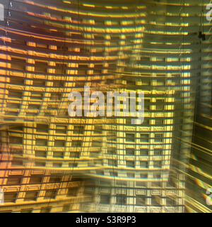 Colorful abstract pattern created with prism in front of camera lens. Facade of a historic building seen as multiple composited images through window with Venetian blinds Stock Photo