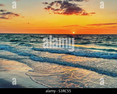Sunset over the waves at Bean Point Beach on Anna Maria Island in Florida Stock Photo