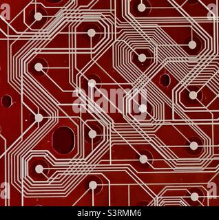 A section of a printed circuit board against a red background Stock Photo