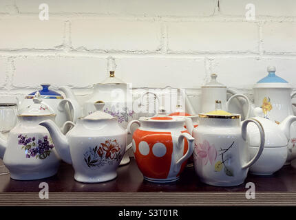 Set of vintage teapots on wooden shelf Stock Photo
