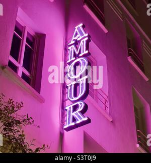 Neon sign with the word “Amour” and pink flood lights Stock Photo