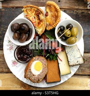 Food flat lay of a plate or platter of Ploughman’s Lunch with scotch egg cheese quiche and pickle Stock Photo