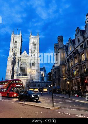 Westminster Abbey with Number 11 red bus and black London taxi cab at dusk Stock Photo