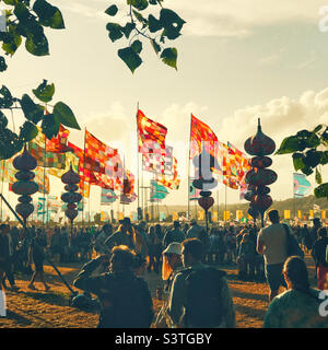 Crowds going to the Other Stage at the Glastonbury Festival 2022 in beautiful late afternoon light Stock Photo