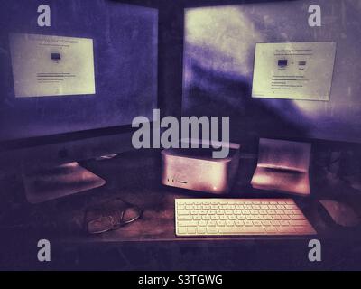 Migrating data to a new Mac Studio Apple computer sitting on a desktop in a home office in Utah, USA. Glow and grunge effects digitally added. Stock Photo