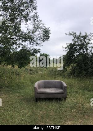 Sofa left in a green field Stock Photo