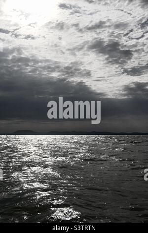 Sun shining through clouds over Lake Balaton looking towards Badacsony, Balatonlelle, Hungary Stock Photo