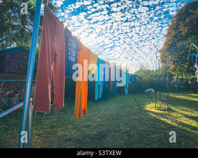 Washing hanging on a washing line with a blue sky with lots of small clouds in the background Stock Photo