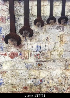Spanners hanging on wall Stock Photo