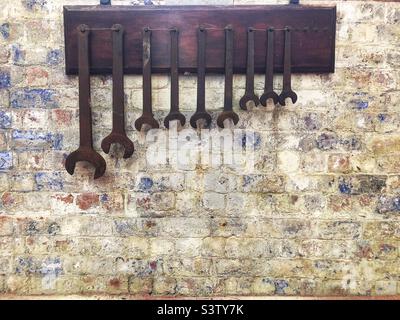 Spanners hanging on wall Stock Photo