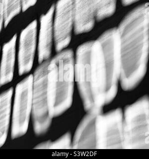 Abstract pattern on concrete wall, created by sunlight reflecting from office building with lots of glass windows Stock Photo