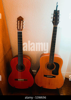 A couple of guitars in a corner of a room. Stock Photo