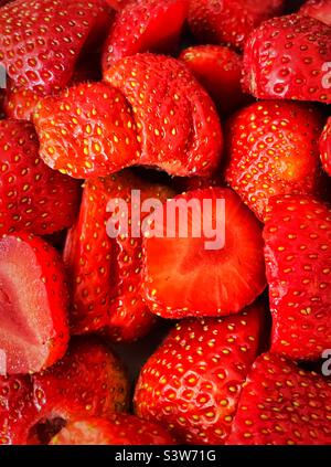 ‘Straight from the garden’ a close up of home grown, washed and sliced strawberries Stock Photo