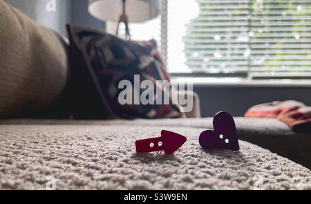 Red arrow button and a purple heart shaped button against a peaceful background Stock Photo