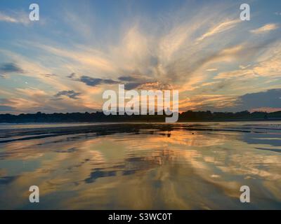 Dramatic sunset reflection on the beach Stock Photo