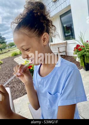 Girl chewing on straw Stock Photo