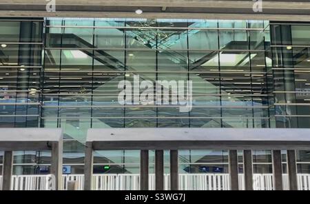 Taken from the passenger pickup area of the Salt Lake Intl Airport, this makes an interesting architectural abstract. In the center you can see crisscrossing escalators inside behind tinted glass. Stock Photo