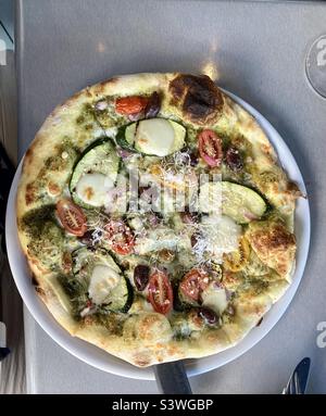 Veggie pizza with zucchini, grape tomatoes, and basil pesto. Stock Photo