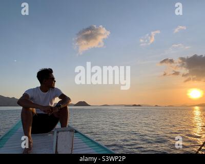 enjoying Flores Sea sunsets on the boat Stock Photo