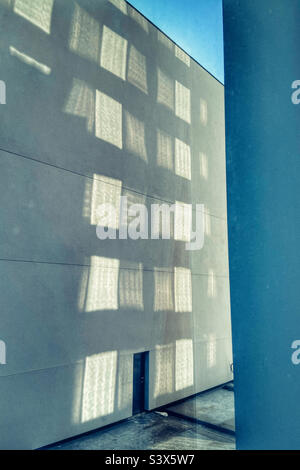 Reflections of windows on concrete wall Stock Photo